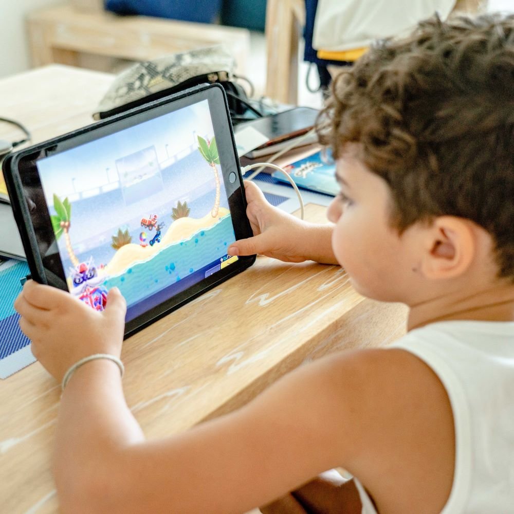 a kid playing an educational game on a black tablet