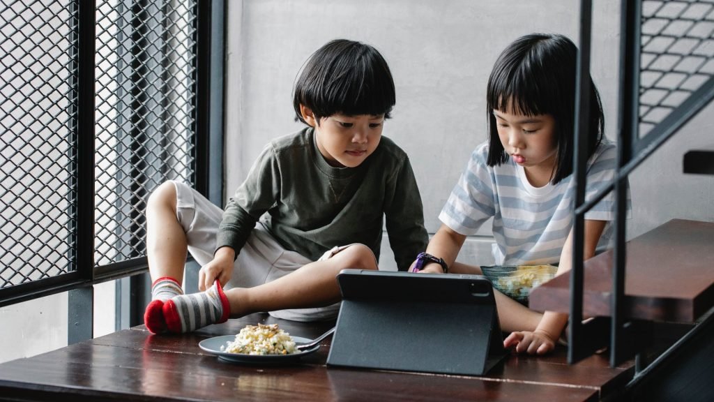 two kids playing educational video games on a tablet