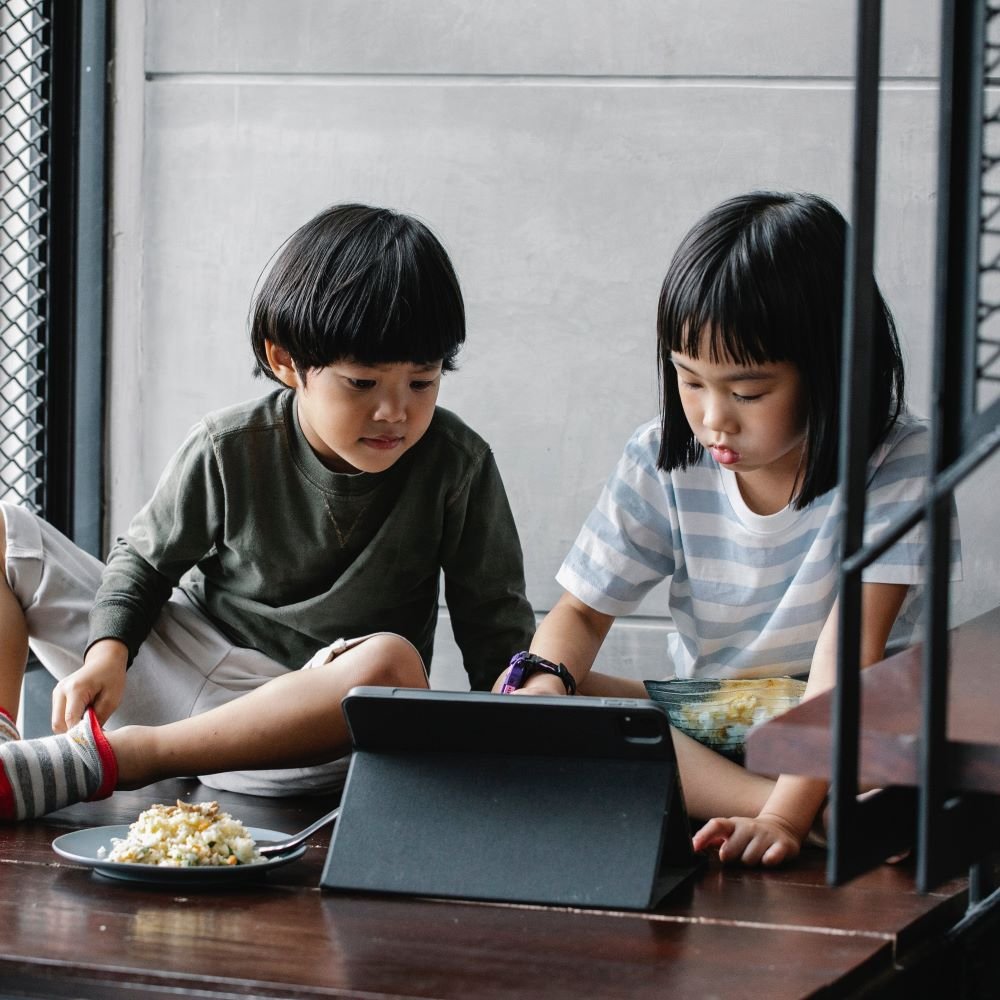 two kids playing educational video games on a tablet